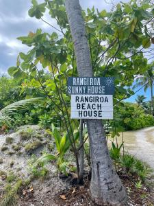 阿瓦托鲁Rangiroa Beach House的海滩屋前树上的标志