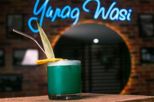 瓦努科YURAQ WASI Hotel/Restobar的坐在桌子上喝一杯绿饮料