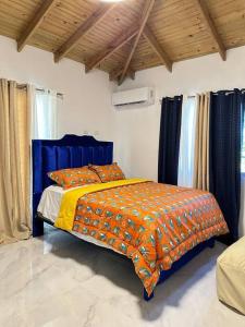 圣地亚哥洛斯卡巴Richie’s House En Licey Al Medio的一间卧室配有一张带橙色毯子的床