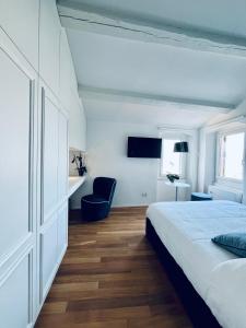 韦内雷港意大利假日度假屋的白色卧室配有床和蓝椅