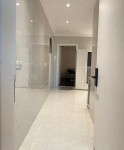 利雅德شقه استديو حي بالمروج的带淋浴的走廊和白色瓷砖地板
