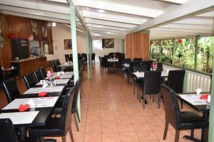 戈罗卡Pacific Gardens Hotel的餐厅内带桌椅的用餐室