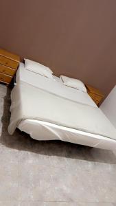 努瓦克肖特Atlantis的一张带白色床单和枕头的床
