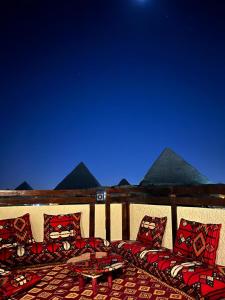开罗Pyramids Era View的庭院设有枕头、桌子和金字塔。