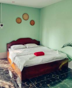 贡布La plage by lee & hap guest house的一间卧室配有一张带红色毛巾的床