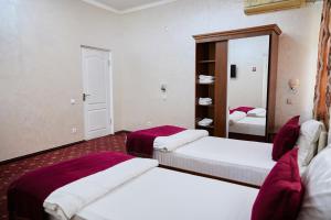 塔什干ART Hotel的酒店客房,设有两张床和镜子