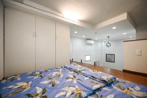 胡志明市Huyen Apartment的一间卧室配有一张带蓝色棉被的床