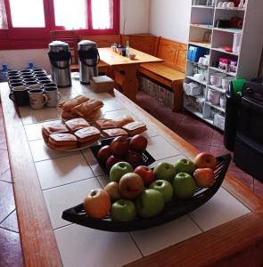 圣地亚哥Hostal Irreal的桌子上装有苹果和橙子的托盘