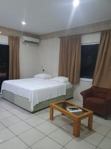 帕拉马里博玛雅公寓的卧室配有1张床、1张桌子和1把椅子