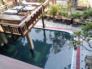 清迈兰纳精品度假酒店的一座游泳池,上面有一座木桥