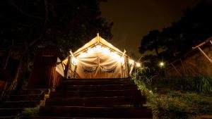 天城Kim Ngan Hills Resort Da Lat.的白色大帐篷,晚上有楼梯