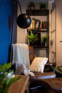 伦敦Cozy Urban Retreat in London的客厅配有真皮座椅和灯