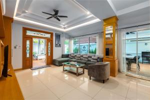 南芭堤雅Gala Villa Pattaya的客厅配有沙发和桌子
