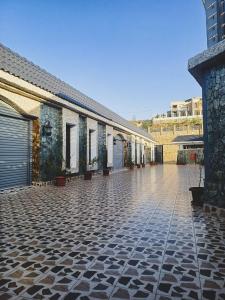 巴勒如拉斯فلل بيات الفيصل Bayat Al Faisal Villas的一座铺有瓷砖地板的建筑和一个庭院