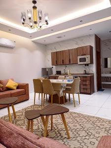 巴勒如拉斯فلل بيات الفيصل Bayat Al Faisal Villas的一间带桌椅的客厅和一间厨房