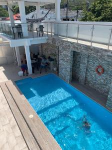 圣安德烈斯Hotel Las Gaviotas的一座大型蓝色游泳池,位于大楼旁边