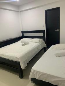 圣安德烈斯Hotel Las Gaviotas的一间卧室设有两张床和黑色橱柜