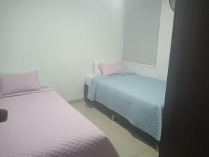 麦德林Hotel Laureles Ivanna的小型客房配有两张床,