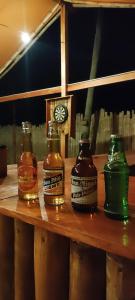 锡基霍尔Kahoy Cottages的木桌旁的三瓶威士忌