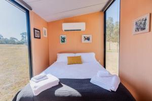 Hermano Farm Stay的一间小卧室,配有床和大窗户