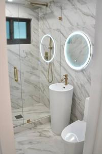 达尼亚滩Stylish home的一间带水槽、卫生间和镜子的浴室