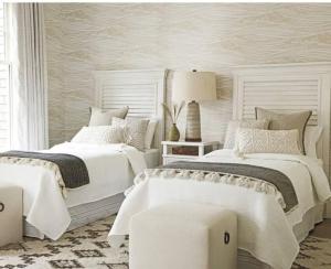 达尼亚滩Stylish home的卧室设有2张床和白色的墙壁。