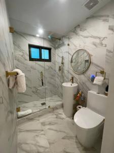 达尼亚滩Stylish home的带淋浴、卫生间和盥洗盆的浴室
