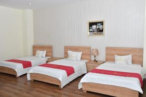 海防Nhà Khách Hương Sen的一间设有两张铺有白色和红色床单的床的客房