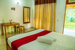 DematapelessaElegant Riverside Resort的一间卧室配有一张床、一张桌子和一个窗户。