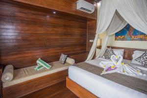 蓝梦岛D'Muncuk Huts Lembongan的配有木墙和木地板的客房中的两张床