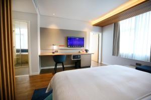 成都成都北站智选假日酒店的酒店客房配有一张床和一张书桌及一台电视