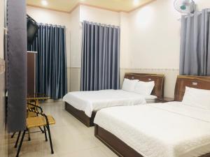 芹苴Huy Hoàng Motel - Cần Thơ的一间酒店客房,设有两张床和电视