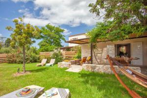 卡尔维Very warm villa "Acacia" with beautiful garden - 46 people的一个带吊床和房子的后院