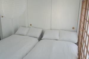 Yamada1999/hotel的白色墙壁客房的两张床