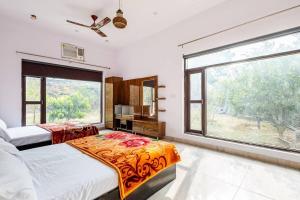 古尔冈Aravali hills resort的一间卧室设有两张床和大窗户