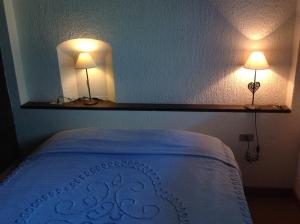 拉特乌伊莱Condominio Colmet的卧室配有一张带两盏灯的墙壁床。