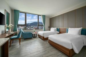 岘港Lupin Center Hotel Danang的酒店客房配有两张床和一张书桌