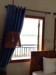 桔井Le Tonle的一间设有蓝色窗帘的窗户的客房