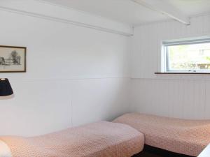 斯瓦讷克4 person holiday home in Svaneke的一间卧室设有两张床和窗户。