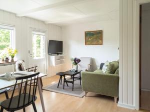 斯瓦讷克4 person holiday home in Svaneke的客厅配有绿色沙发和桌子