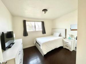盐湖城Mountain View的一间小卧室,配有一张床和电视