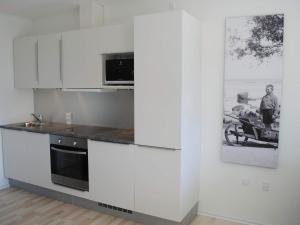 斯瓦讷克4 person holiday home in Svaneke的厨房配有白色橱柜和微波炉