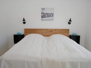 阿灵厄4 person holiday home in Allinge的客房内的一张带白色棉被的床
