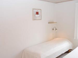 阿灵厄4 person holiday home in Allinge的白色卧室配有床和灯