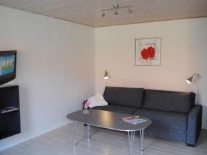 阿灵厄4 person holiday home in Allinge的客厅配有沙发和桌子