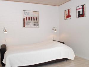 阿灵厄4 person holiday home in Allinge的一间白色卧室,配有一张床和两盏灯