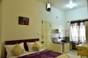 马迪凯里Coorg Lotus Villa的一间卧室配有一张床和一个小厨房