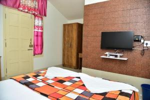 马迪凯里Coorg Lotus Villa的一间卧室配有一张床和一台平面电视