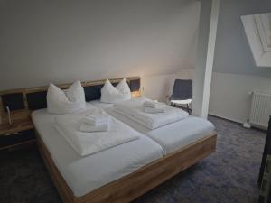 奥斯赛拜-屈隆斯博恩Villa Ludwigsburg的一间卧室配有一张白色大床和蓝色椅子