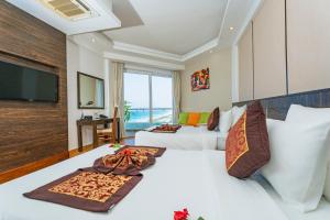 Cam LâmOcean Waves Resort Cam Ranh的配有一张床和一台平面电视的酒店客房